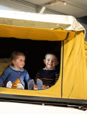 two kids on a yellow car tent