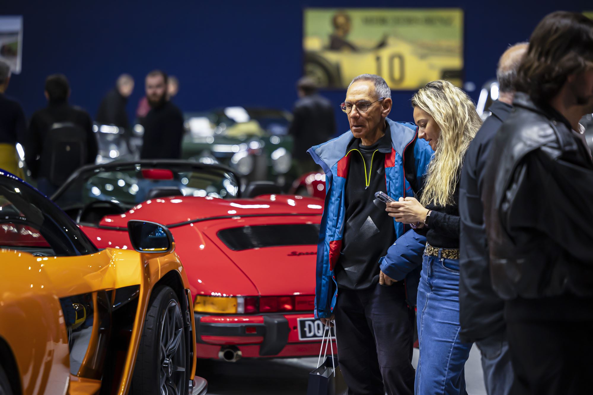 Visitors looking at luxury cars