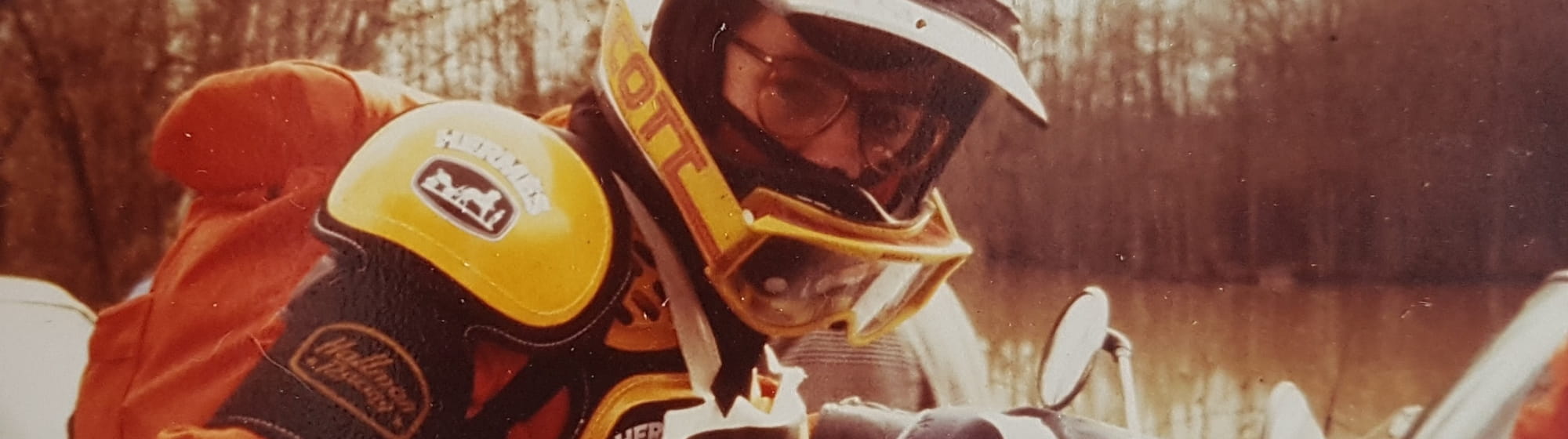 Photo d'époque d'Éric de Seynes en tenue de moto et sur une moto, devant un lac