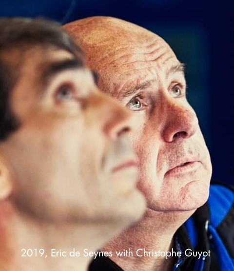 Photo with caption of Éric de Seynes looking up, with Christophe Guyot