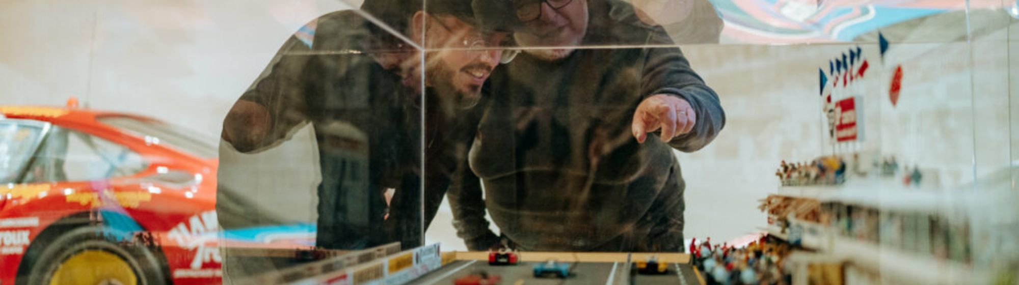 2 hommes regardent une miniature d'un stade de course automobile