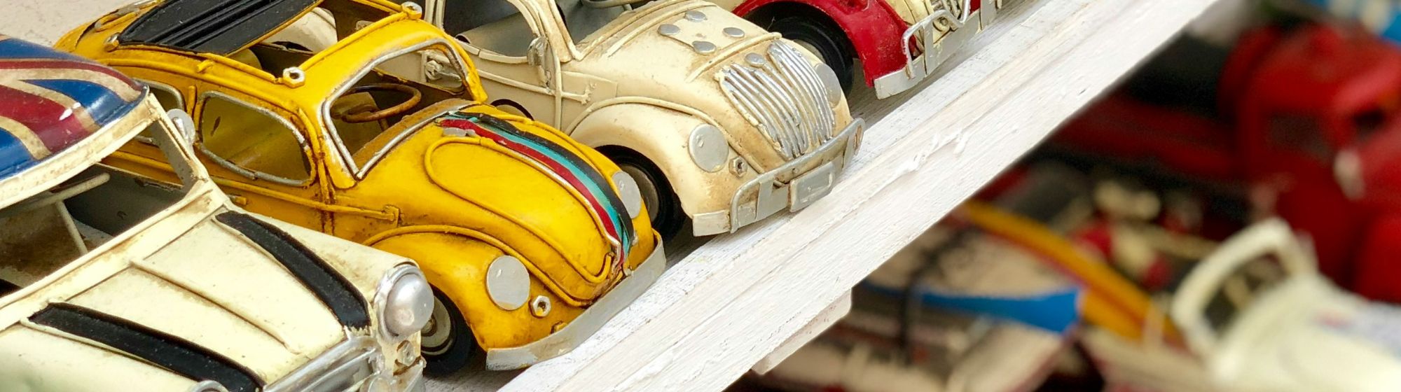 Banner image of vintage toy cars on a shelf