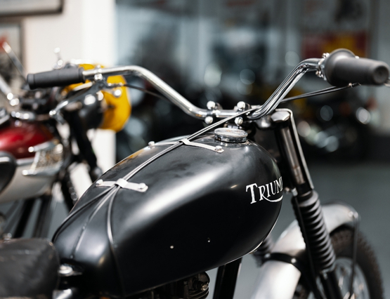 close-up of the top of a black Triumph with handlebars