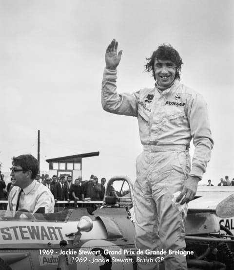 black and white picture of Stewart in front of a F1 car