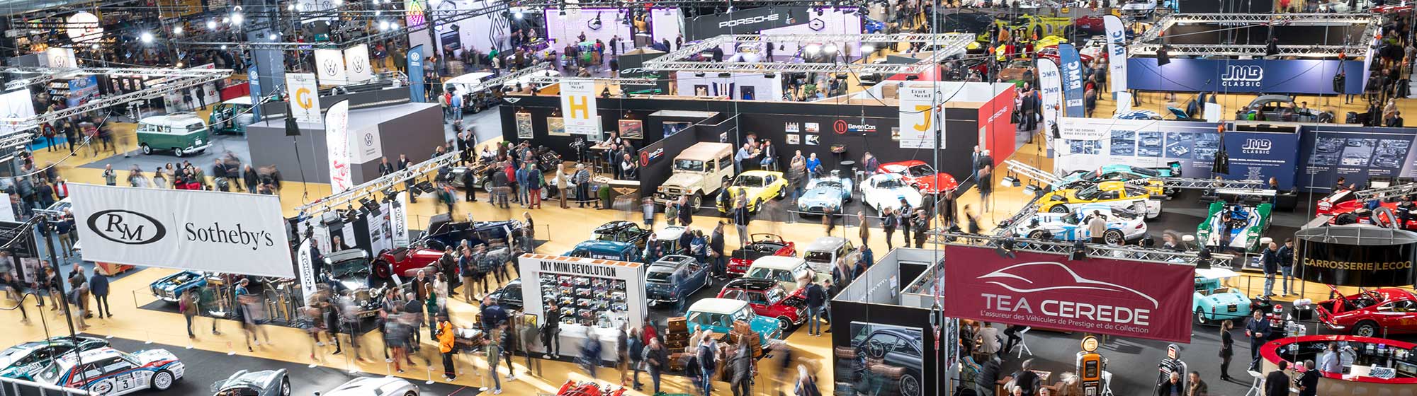 Photo aérienne du salon Rétromobile avec de nombreux stands et une foule de visiteur