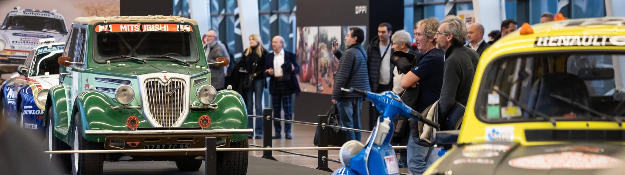 Voitures de collection du Dakar en exposition, avec des gens autour