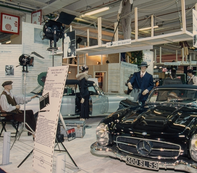 stand archive du salon rétromobile avec des voitures de collection mercedes sous les projecteurs