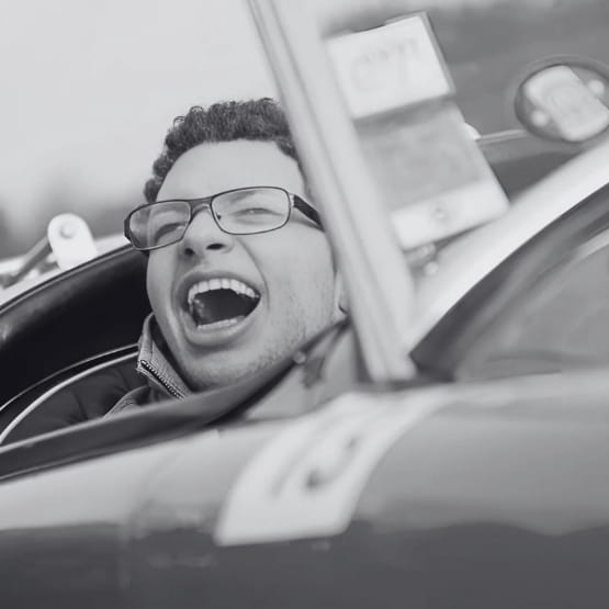 Image noir et blanc d'un homme handicapé souriant dans une voiture