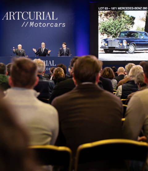 Car auction in a blue room